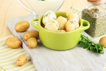 Tender young potatoes with sour cream and herbs in pan