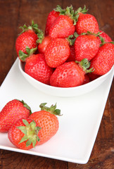 Fresh strawberry in bowl on wooden background