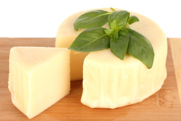 Cheese mozzarella and basil on cutting board isolated on white