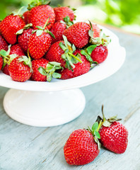 strawberry berry with green leaf on a white plate