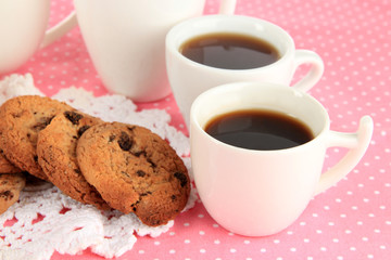 Cups of coffee with cookies on pink napkin close-up