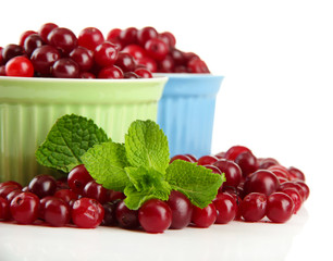 Ripe red cranberries in bowls, isolated on white.