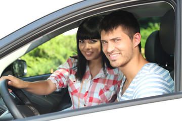 Beautiful happy young couple driving car