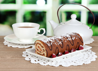 Sweet roll with cup of tea on table in room