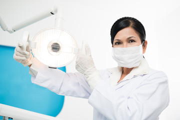 Naklejka premium Adjusting dental lamp