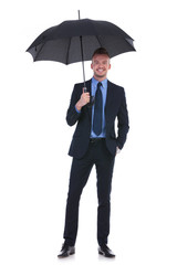 business man holds umbrella and hand in pocket