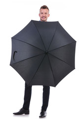 business man stands behind opened umbrella