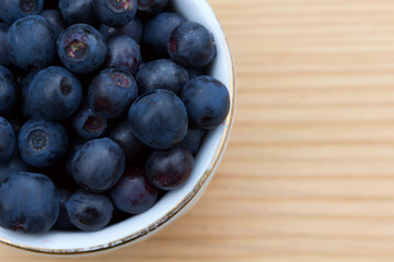 Blueberries in a bowl on a wooden table.