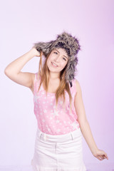 Hapy girl in fur cap and pink background