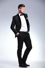 business man with hands in pockets looks away