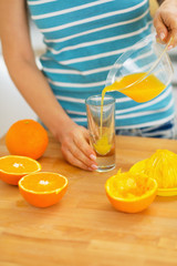 Closeup on woman pouring juice into glass