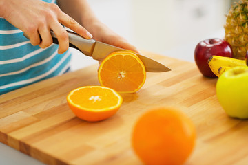 Naklejka premium Closeup on woman cutting orange