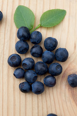 Blueberries with green  leaves on a wooden table.
