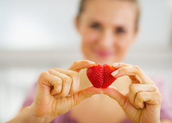 Closeup on woman making heart with strawberry slices