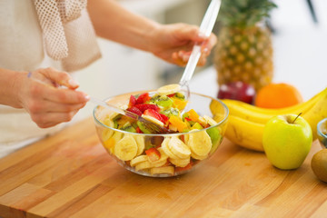 Closeup on woman making fruits salad