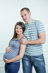 Pregnant couple posing at studio