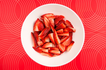 Chopped strawberries in a bowl against a patterned background