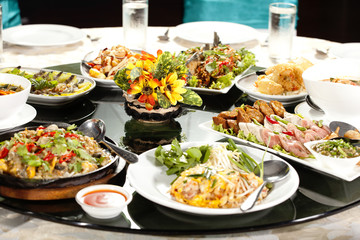 meal time, full round table with colorful food in restaurant