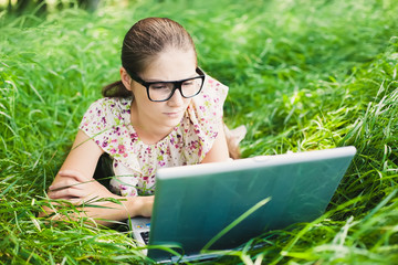 young woman with glasses using laptop