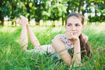 Naklejka na ściany i meble young woman lying on the grass