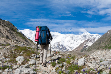 Fototapeta premium Hikier is approaching wall covered with snow in Caucasus mountai