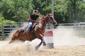 Young adult woman barrel racing