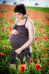 Pregnant woman in a flowering poppy field