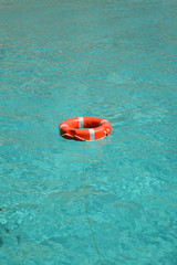 Obraz premium Orange lifesaver floating on turquoise sea