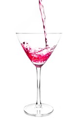 filling a glass with red cocktail and splashing