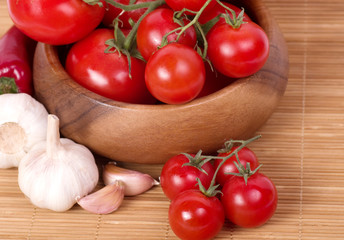 Fresh tomatoes with garlic in wooden bowl