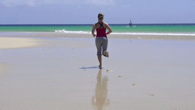 Young woman jogging on the beach, slow motion shot at 240fps 