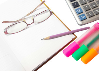 Pencil on a diary  with glasses, pens, highlighters and a calcul
