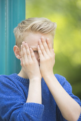 Fototapeta premium Young teenage boy gazing through fingers