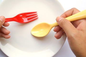 yellow spoon and red fork with dish