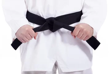 Fototapete Kampfkunst Kampfsport-Mann, der seinen schwarzen Gürtel bindet, isoliert auf weiß