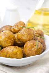 baked new potatoes with spices and rosemary in a bowl, vertical