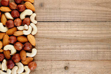 Mix of hazelnuts, almonds and cashew nuts on wooden background