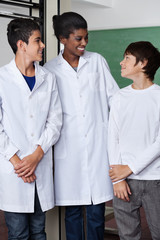 Teacher And Teenage Boys Standing Together In Science Lab