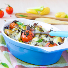 Mixed vegetable in blue bowl baked in the oven with cheese