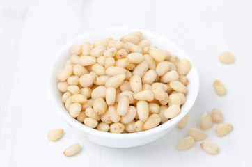 pine nuts in a white bowl, top view