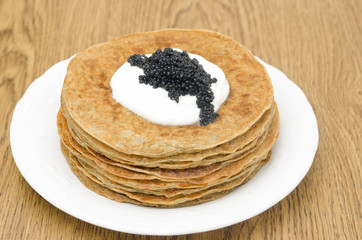 potato pancakes with sour cream and caviar, selective focus