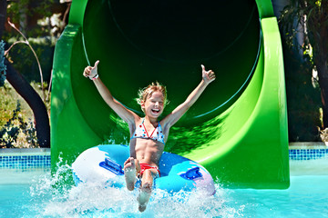Child on water slide at aquapark. - 53746499