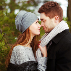 Sensual fashion outdoor winter portrait of young beautiful happy smiling couple in love posing together in park 