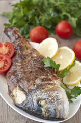 Fried (roasted) Fish (Dorado) Garnished with Lemon, Tomato