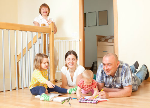 Portrait of happy smiling three generations family sits on parqu