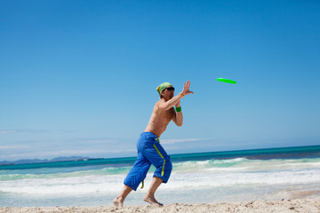 sportlicher mann spielt frisby frisbee am strand im sommer