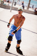 junger sportlicher mann mit inline skates im sommer