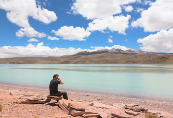 Man sitting on the shore of lagoon Celeste, Bolivia