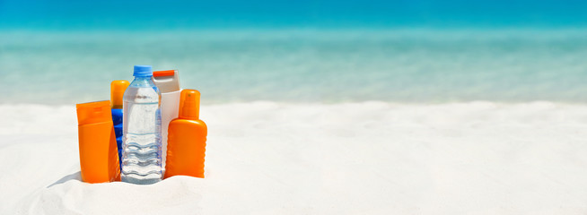 water and sun protection cream on the beach. travel background