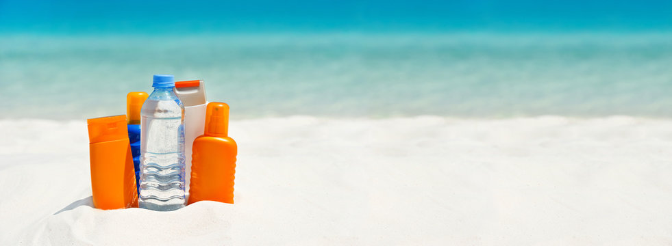 water and sun protection cream on the beach. travel background